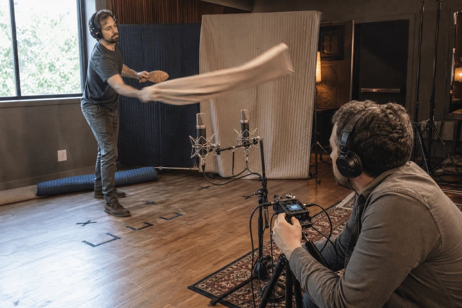 Dos artistas Foley graban movimiento de tela frente a micros estéreo
